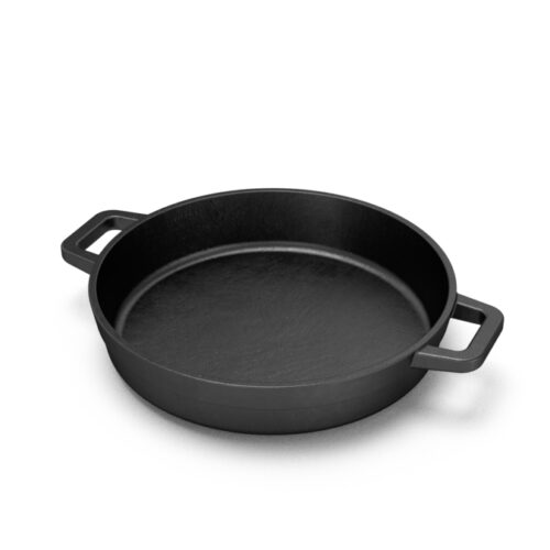 The Bastard litoželezna ponev z dvema ročajema, primerna za uporabo na kamado žaru, prikazana s pripravljeno jedjo.