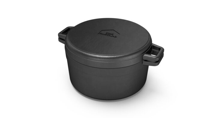 The Bastard litoželezni lonec z rebrasto ploščo, prikazan s pokrovom, ki služi kot rebrasta plošča za pečenje, primeren za uporabo na kamado žaru.